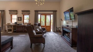 A spacious living room with a fireplace, a television, and a dining area with a kitchen counter.