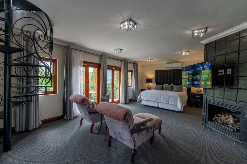 Ein Schlafzimmer mit Bett, Fernseher, Kamin und Treppe.