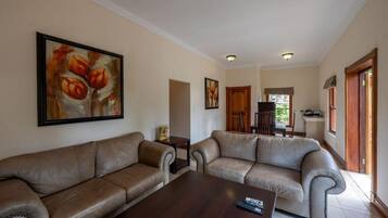 Suite familiar, patio, vista al jardín | Área de sala de estar