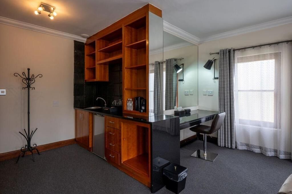 A modern bathroom with a glass shower enclosure, a wooden vanity, and a mirror.