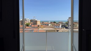 A view from a balcony with a clear sky, buildings, and a distant coastline. - Location: in a residential area, a few steps from the sea and all services.Description: apartment on the fourth floor of a building with lift. Living room with terrace overlooking the sea - bright kitchen with dining table and balcony - double bedroom wi (SENIGALLIA)