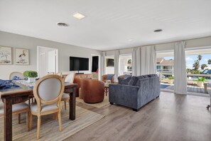 A spacious living area with a dining table, sofas, and a TV. - Salty Sandpiper (Rockport)