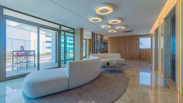 A modern hotel lobby with a curved seating area, large windows, and a wooden wall.