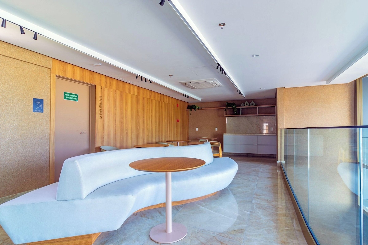 A modern waiting area with a curved reception desk, a round table, and a glass partition.
