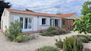 A two-story building with a red-tiled roof, a covered porch, and a gravel driveway. - Pointeau House (Saint-Georges-d'Oléron)