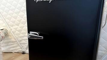Een zwarte koelkast met de merknaam 'Frigidaire' bovenaan.