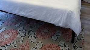 Uma cama em um quarto tipo tenda, com um chão estampado.