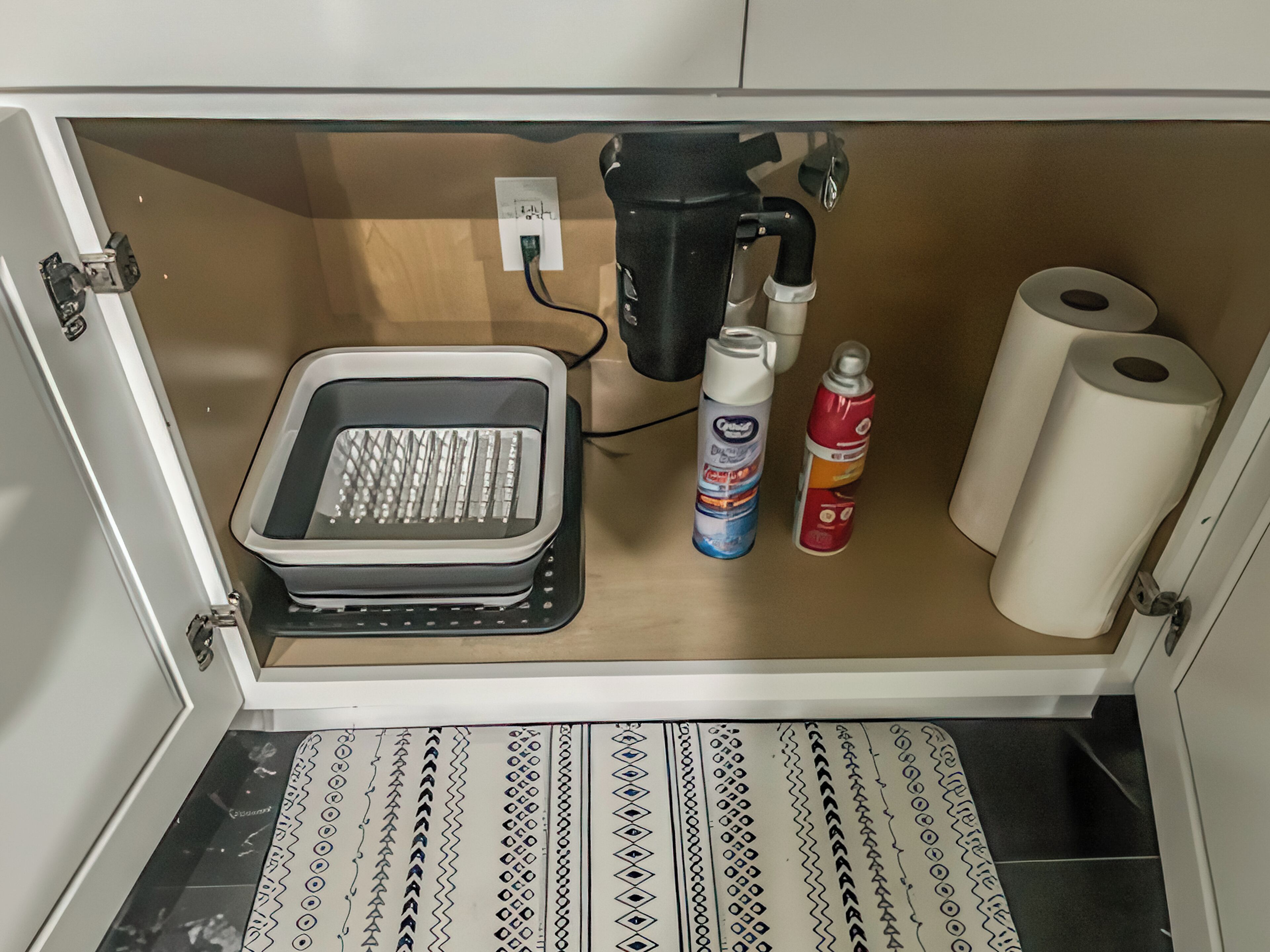 A kitchen with a built-in toaster, a coffee maker, a bottle of dish soap, and two rolls of toilet paper.