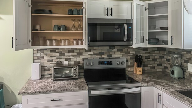 A kitchen with white cabinets, a microwave, a toaster, and a blender. - Guest Villa (Cedar Hill)