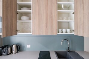 Eine Küche mit Holzausstattung, einem Spülbecken, einem Wasserkocher und einem Toaster.