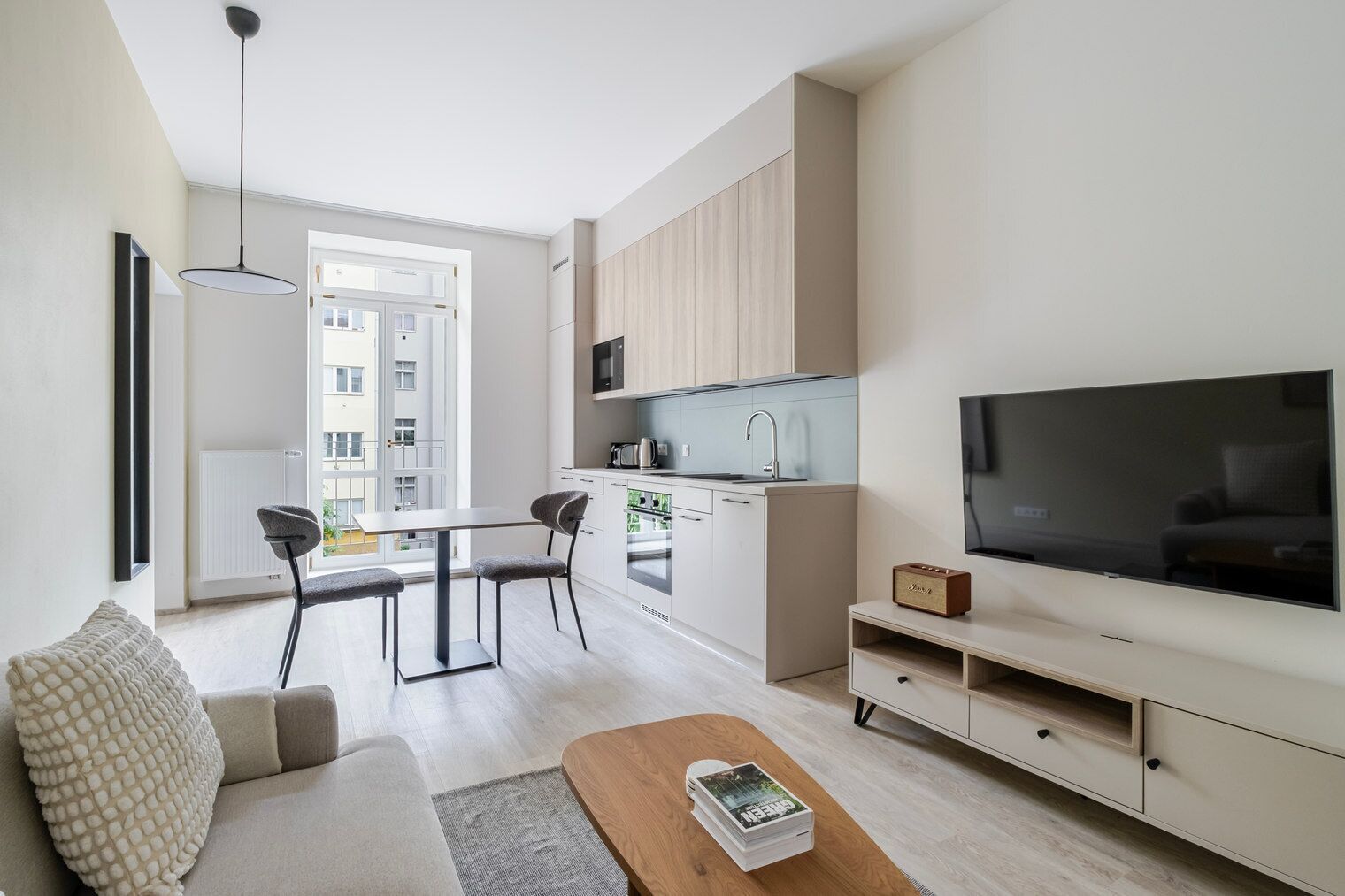 Eine moderne Wohnung mit Essbereich, Küchenzeile und einem großen Fernseher.