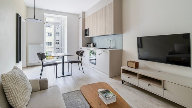 En modern lägenhet med matplats, pentry och en stor TV.