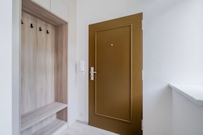 Ein Flur mit einem Holzschrank, einer braunen Tür und einer weißen Wand.