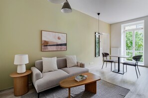 Ein modernes Wohnzimmer mit einer Couch, einem Couchtisch und einem Essbereich mit Stühlen.