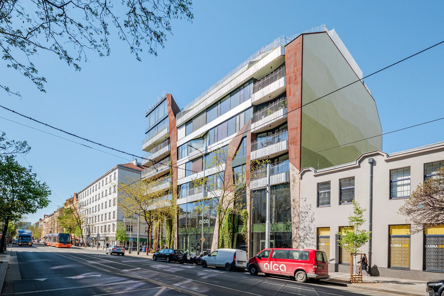 A modern building with multiple floors, large windows, and a mix of glass and metal facade.