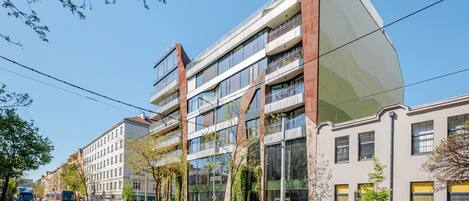 A modern building with multiple floors, large windows, and a mix of glass and metal facade.