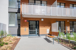 Ein Gebäude mit modernem Design, ausgestattet mit einem Balkon, der ein Metallgitter, eine Bank und eine Tür mit der Nummer 1068 aufweist.