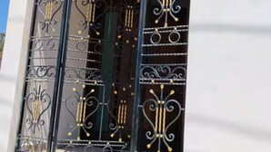 A building entrance with a large number '165' above the door, a wrought iron gate with decorative elements, and a sign with the logo and name 'NACHO'. - Nacho Apartments (Puerto Vallarta)