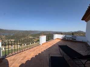 A terrace with a view of a lake and hills, furnished with a table and chairs. - Casa Vesta (Zufre)