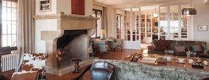 Una sala acogedora con chimenea, asientos cómodos y vista al comedor.