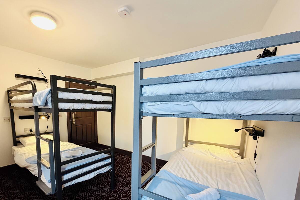 A room with bunk beds, a door, and a patterned floor.