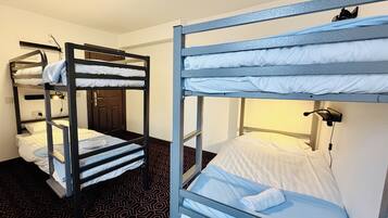 A room with bunk beds, a door, and a patterned floor.
