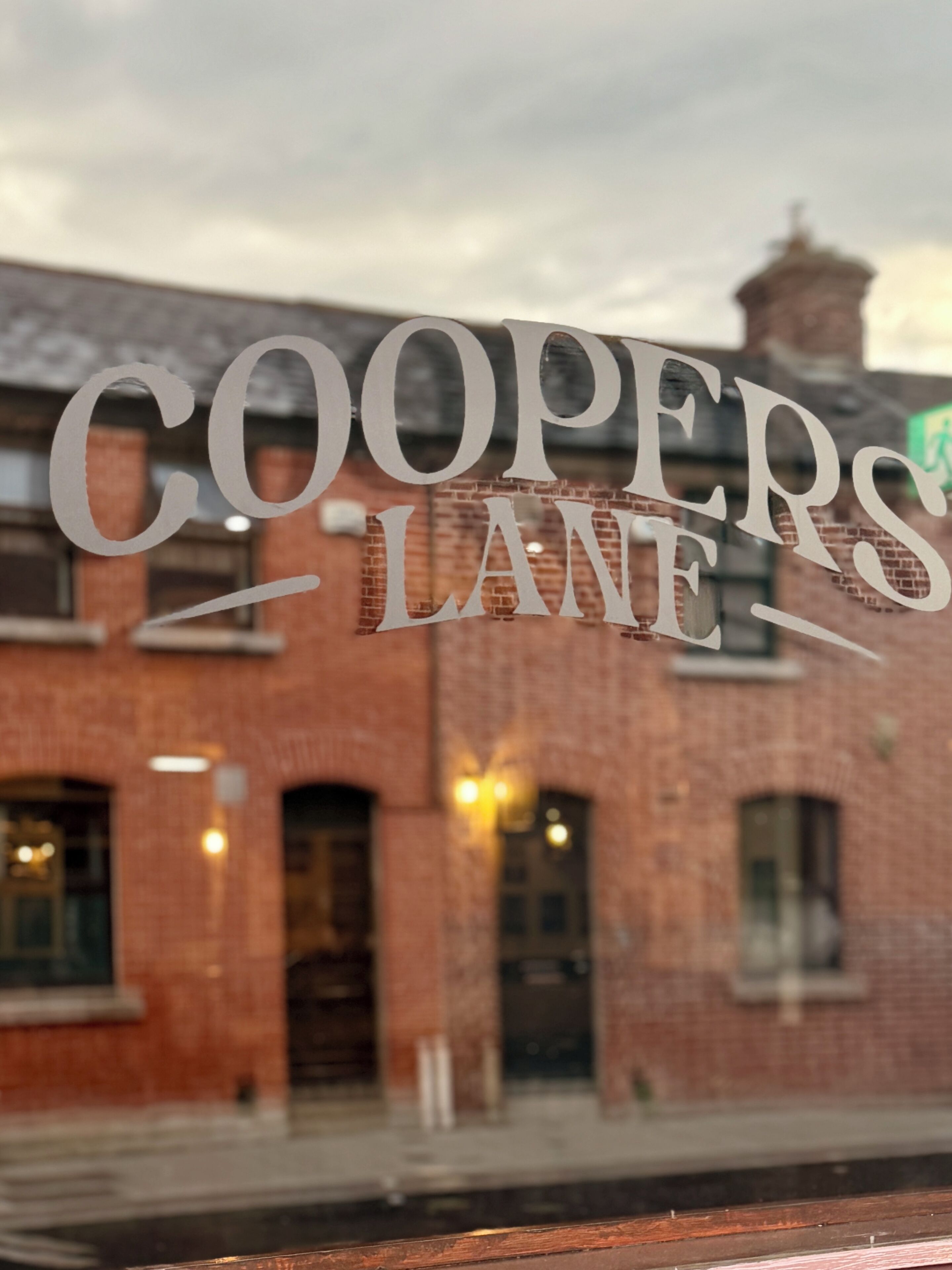 Una ventana con el texto 'COOPERS LANE' en una tipografía estilizada.