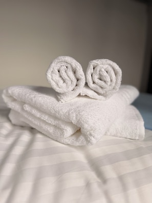 A stack of white towels with a rolled towel on top. - Coopers Lane (Dublin)
