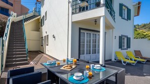 A dining area with outdoor seating, a staircase, and a view of the surrounding landscape. - Desertas Vista Casa by LovelyStay (Gaula)