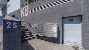 Ein Gebäude mit einem großen 'K8'-Schild, einem Briefkasten und einer Tür mit der Aufschrift 'CASA DO LIXO'.