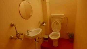 Un bagno compatto con il water, il lavandino e uno specchio.
