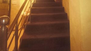 A staircase with a handrail, leading to a landing with a light fixture. - Shades of Kashi with an artistic and cozy stays for couple and family. (varanasi)
