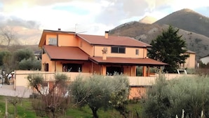 Una casa a due piani con tetto spiovente, un garage e vista su una montagna.