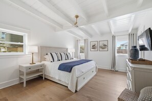Ein Schlafzimmer mit Bett, Nachttischen, einem Schminktisch, einem Fernseher und einem Fenster.