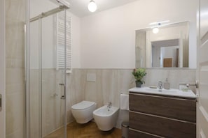 A modern bathroom with a glass shower enclosure, a toilet, a bidet, and a vanity with a mirror. - Florence Central Bright Stay - Near the Duomo (Florence)