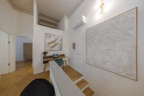 A modern interior with a desk, artwork, and a staircase. - Florence Central Bright Stay - Near the Duomo (Florence)