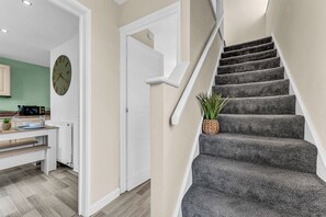 Un escalier avec une rampe et un pot de fleurs placé sur le palier.