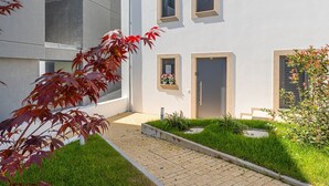 Ein modernes Gebäude mit gepflastertem Weg, einer Tür und Fenstern.