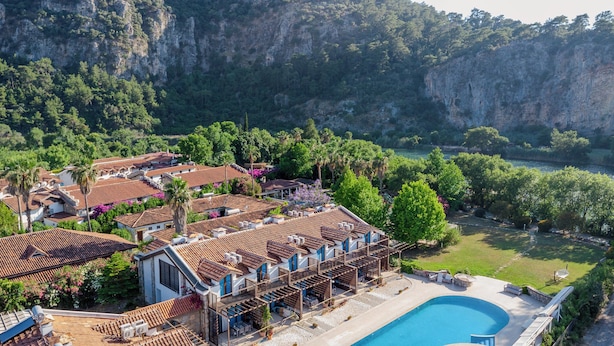 Una villa costera con piscina, tejados escalonados y vistas al mar.