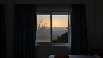 A room with a bed, a window, and curtains.