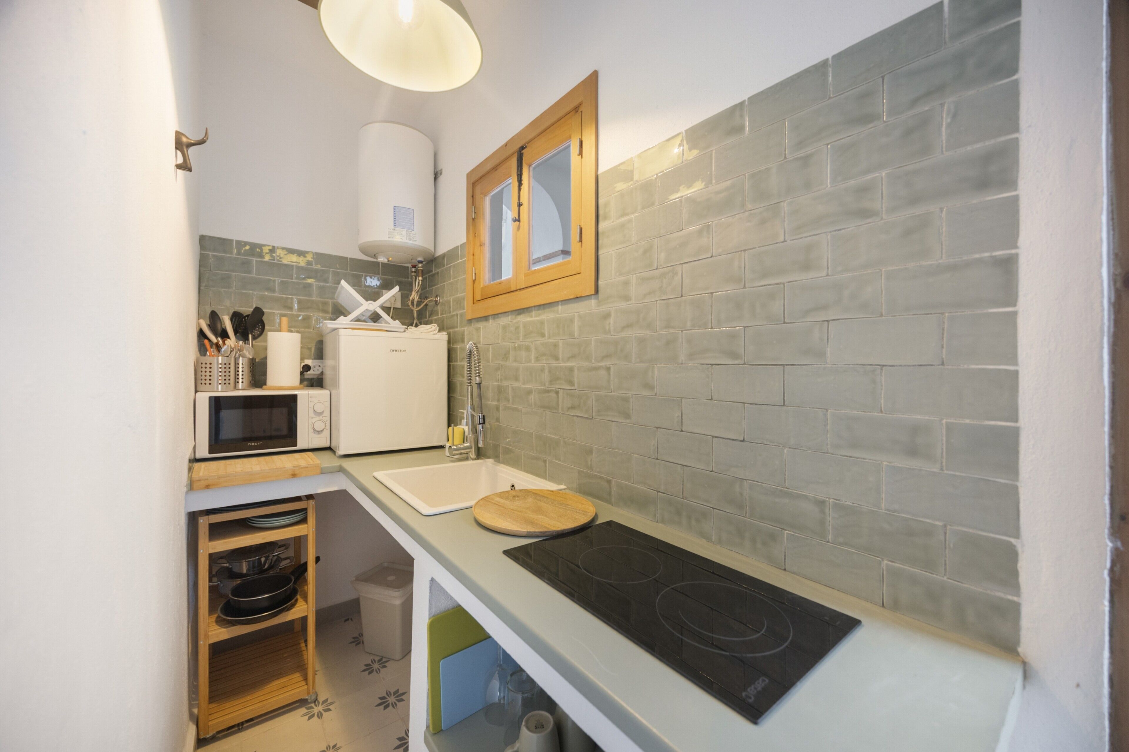 A compact kitchen with a microwave, sink, and stove.