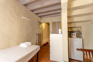 A small, compact room with a single bed, a white refrigerator, and a kitchenette area. - Single Room in a Historic Building (Florence)
