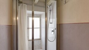 A shower with a glass door, a showerhead, and a window. - Single Room in a Historic Building (Florence)