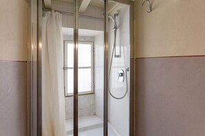 A shower with a glass door, a showerhead, and a window. - Single Room in a Historic Building (Florence)