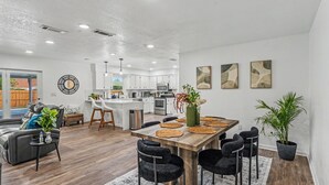 Una cocina moderna con armarios blancos, electrodomésticos de acero inoxidable y una isla central.