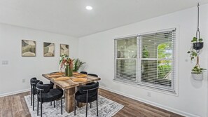 A dining area with a wooden table, black chairs, and a white rug. - Conveniently Located - S Lakeland Pool Home, Pet and Family Friendly (Lakeland)