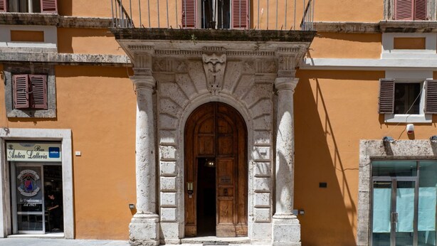 Un edificio con un portale ad arco centrale, un balcone con ringhiera e un cartello con la scritta 'Antica Lateria'.