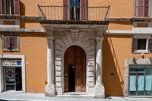 Un bâtiment doté d’une porte d’entrée centrale en arc de cercle, d’un balcon avec une balustrade et d’une enseigne indiquant « Antica Lateria ».