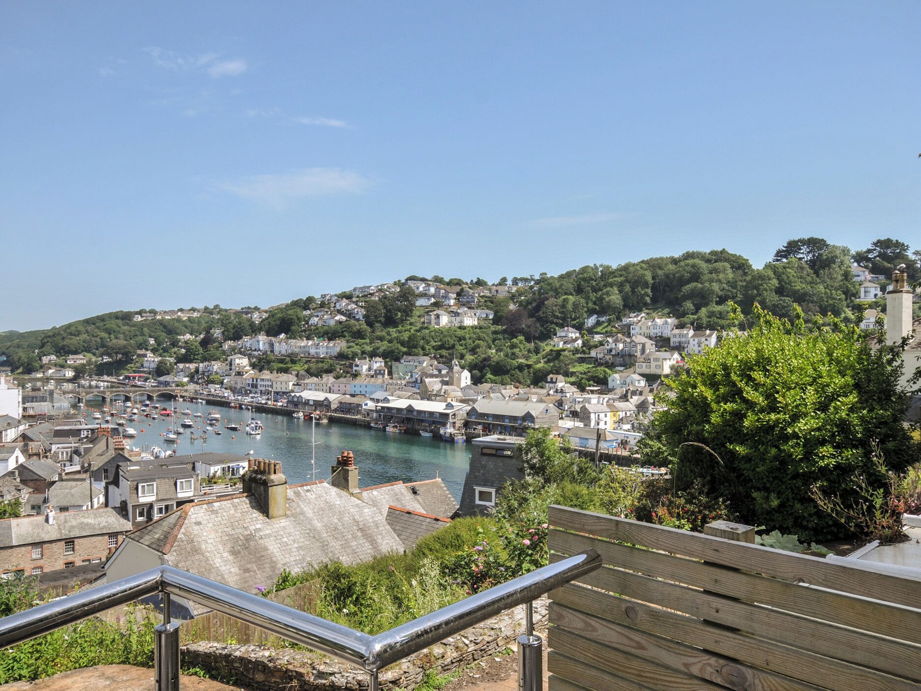 A coastal town with a harbor, buildings, and a hill in the background.