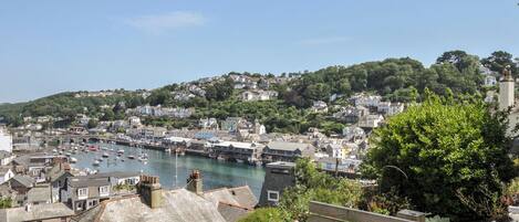 A coastal town with a harbor, buildings, and a hill in the background.